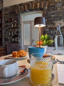 戈里齐亚Castel San Mauro的一张桌子,上面放着一盘食物和一杯橙汁
