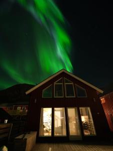 莱克内斯Rorbu Skreda的天空中绿意盎然的北极光度假屋