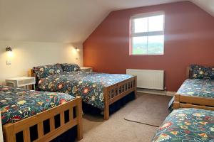 MurrooghInto The Burren的一间卧室设有三张床和窗户。