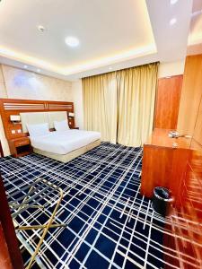 艾卜哈Shatha Abha Furnished Units的酒店客房带一张床,房间带蓝色地板。