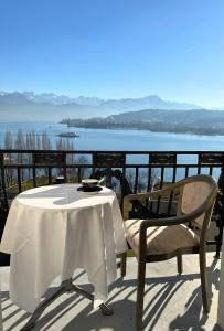 卢塞恩Hotel Royal Luzern的水景阳台的桌椅