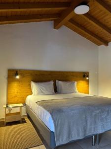 米尔芳提斯城Quinta da Boavista的一间卧室配有一张大床和木制床头板