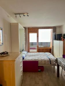 奥斯塔Residence Ciel Bleu - Fraz Pos的一间卧室配有一张床、一张书桌和一个窗户。