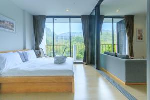 Ban Huai Sok NoiMountain View Retreat at Khaoyai的一间卧室配有一张床、一张沙发和窗户。
