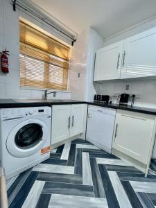 伦敦Deluxe Apartment - Next to Kings Cross - Eurostar & Euston Station的白色的厨房配有洗衣机和烘干机