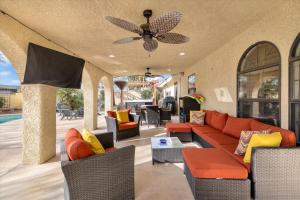 拉斯维加斯Ranch style villa with pool and spa的客厅配有沙发、椅子和吊扇