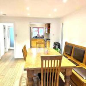 亨顿Inviting 4-Bed House in Finchley London的一间带木桌和椅子的用餐室