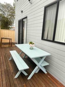 杰斯蒙Maya Newcasle 6 bedrooms home的野餐桌和甲板上的长凳