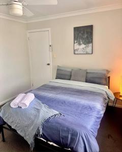 杰斯蒙Maya Newcasle 6 bedrooms home的一间卧室配有一张带紫色床单的大床