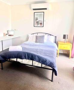 杰斯蒙Maya Newcasle 6 bedrooms home的一间卧室配有一张带蓝色棉被的床
