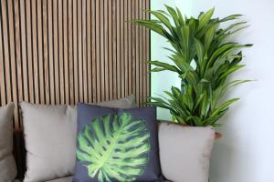 马贝拉Tropical Old Town Marbella的沙发上一组枕头,有两只植物