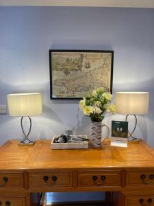 圣贾斯特Cobble Cottage的一张桌子,上面有两盏灯和一张墙上的地图