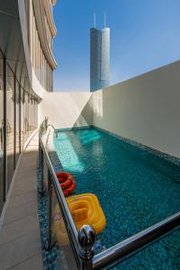 利雅德Hadab Al Sahafa的一座建筑中一座带黄木筏的游泳池