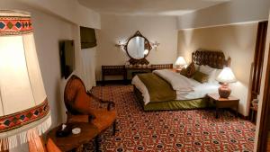 奎达Quetta Serena Hotel的一间卧室配有一张床、镜子和椅子