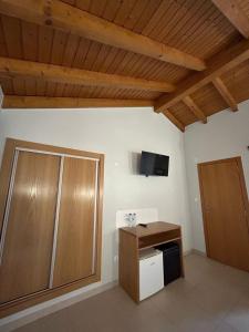 米尔芳提斯城Quinta da Boavista的一间房间,配有橱柜和墙上的电视