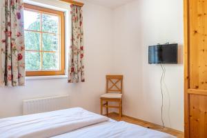 圣迈克尔隆高Stranach Appartements的一间卧室配有一张床,墙上配有电视