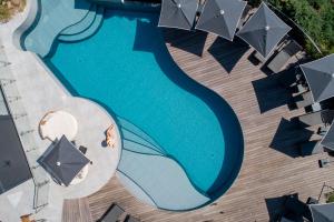 卡尔维Hotel L'Acquale的享有带遮阳伞的游泳池的顶部景致