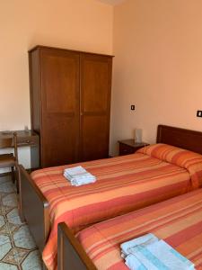 Piana CrixiaHotel Villa Carla的酒店客房设有两张床和橱柜。