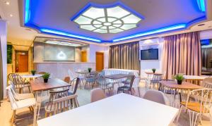 利迈纳里亚Hotel Discovery Thassos的一间带桌椅和吊灯的餐厅