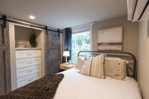 新布朗费尔斯Pet friendly Tiny House Rental with new Access to Guadalupe River NBTX的一间卧室配有一张床、一个梳妆台和一扇窗户。