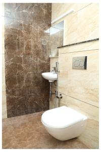 拉马纳塔普拉姆Starwin Residency的浴室配有白色卫生间和盥洗盆。