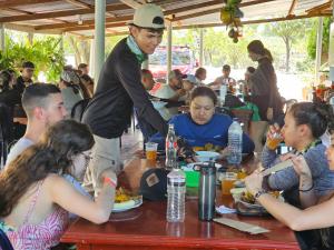 比利亚维哈Hostal Sol de Verano Doña Lilia的一群坐在餐桌上吃食物的人