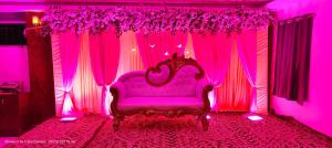 巴特那The Ashiyana Inn Hotel的紫色的客房配有一张床和粉红色的窗帘