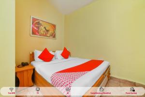 巴加OYO Royal Castle Near Baga Beach的一间卧室配有红色和白色枕头的床