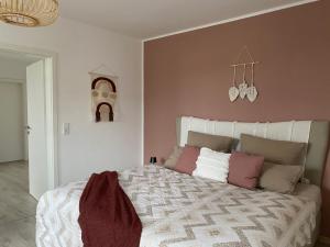 比勒费尔德Boho Appartement的卧室配有一张带粉红色墙壁的大床