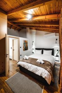 约阿尼纳KONHOUSE στο ιστορικό κέντρο的一间卧室设有一张大床和木制天花板。