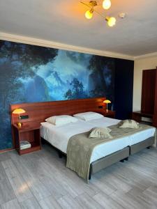 艾斯登Hotel Restaurant Hestia的一间卧室设有两张床,墙上挂着一幅大画