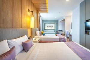 曼谷Royal Rattanakosin Hotel SHA Plus的酒店客房设有两张床和电视。