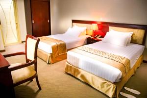 基加利Hill View Hotel Kiyovu的酒店客房,配有两张床和椅子
