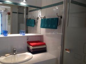 普罗旺斯艾克斯Allées Provençales的浴室设有水槽和带红色凳子的淋浴