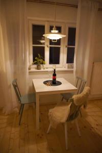 施泰因加登Oide Schreinerei的餐桌、椅子和一瓶葡萄酒