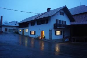 施泰因加登Oide Schreinerei的一间白色的房子,晚上门亮了