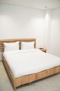 突尼斯Hôtel Suisse Tunis的一张铺有白色床单和木架的床