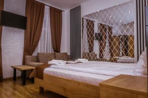 锡比乌4Rooms Central Sibiu的一间卧室配有一张大床和一张沙发