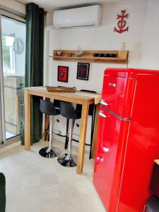 勒格罗-迪鲁瓦LE FLORIDE B Folco de baronchelli的厨房配有红色冰箱和木桌
