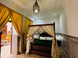 乌季达Dar Al Fassia的一间卧室配有一张天蓬床和吊灯。