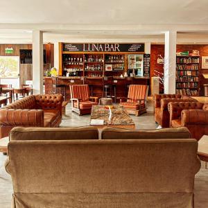厄尔查尔坦鲁纳尤姆宾馆的一个带真皮沙发和椅子的图书馆和一个图书馆