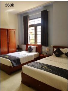 Plei Brel (2)Khách sạn Khải Hoàn的酒店客房设有两张床和窗户。