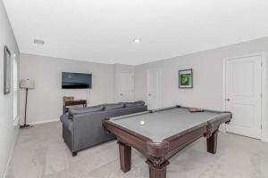 默特尔比奇Tee Time-Golf Course Home with Pool Table, Ping Pong, and More!的带沙发和台球桌的客厅