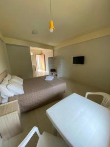 特拉曼达伊Lebanon Praia Hotel的卧室配有一张床和一张桌子及椅子