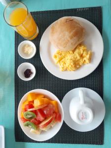 比亚米尔港HOSTAL TERO REAL的一张桌子,上面放着两盘早餐食品和一杯橙汁