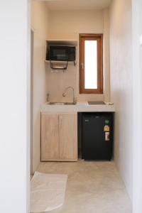 帕干岛Nymph Hideout的一间带水槽和冰箱的小厨房