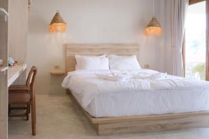 帕干岛Nymph Hideout的一间卧室配有一张带白色床单的床和一扇窗户。