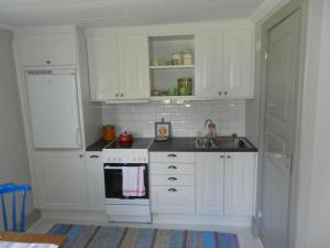 卢德维卡Charming renovated seventeenth century cottage的厨房配有白色橱柜和水槽