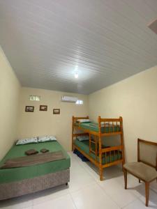 圣加布里埃尔Pousada Ferreira的一间卧室配有两张双层床和椅子