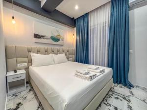 卡萨米尔Rumani 3 Islands Hotel的一间卧室配有蓝色窗帘的床